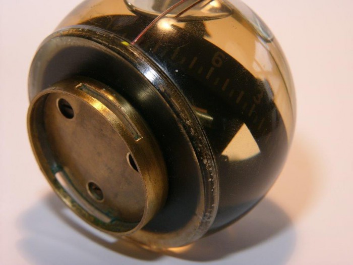 Das Kugelgehäuse hat einen Durchmesser von 70 mm und ist mit dem unteren Boden verklebt, man sieht Luftblasen im Kleber bei genauerem Hinsehen.  Wie bekommt man die Gehäuseteile auseinander?  Die Klebeverbindung läßt sich vielleicht mit Wärme im Wasserbad lösen.  Dusan schickt noch einen zweiten Kompass mit schief hängender Rosenkarte, an dem kann ausprobiert werden.