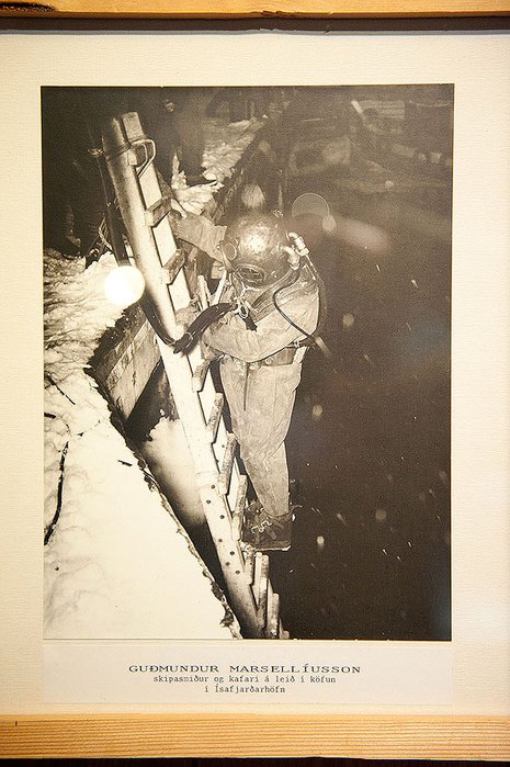 Dies ist ein Wandbild im Rahmen neben der Austüstung.<br />Phil Thurtle: „The monochrome photograph of the diver working is not using this helmet as the helmet looks bery much like a US Navy Mk V“