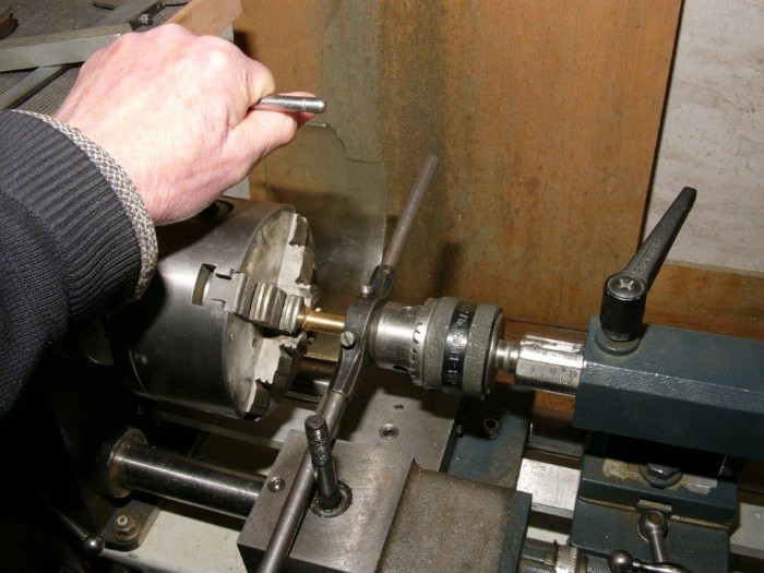 Außengewinde kann man auch so genau schneiden. Mit dem Bohrfutter drückt man das Schneideisen samt Halter gegen das Werkstück, so richtet es sich genau aus.  Mit dem Schlüssel als Verlängerung dreht man das Backenfutter mit dem Werkstück ins Schneideisen.  Mit dem Reitstock drückt man das Werkzeug gefühlvoll nach.