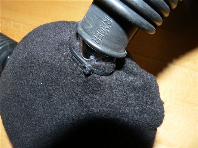 Am Ausatemstutzen wird das Vlies mit einem Kabelbinder abgedichtet.  Auch hier dürfen keine Luftblasen frei entweichen.   Auf dem Foto sieht man, das der Stoff  vorn in der Mitte unter dem Kabelbinder herausgeschlüpft ist, das darf nicht sein, sonst ist die Wirkung ebenfalls dahin.